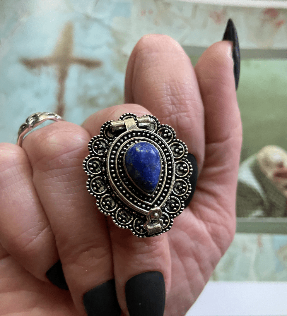 sterling silver poison ring with a deep blue stone