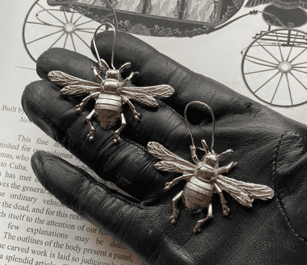 Metal Bee Earrings on the Palm of a Person